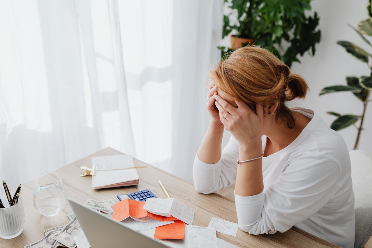 home-hero Woman stressed over financial receipts at a desk, dealing with expenses and calculations.